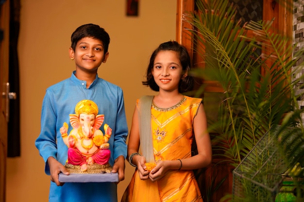 Pequeños hermanos indios con lord ganesha.