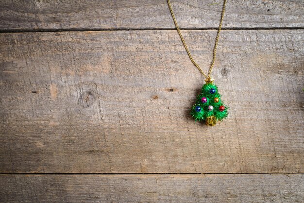 pequeños juguetes de árbol de Navidad en la rama de pino en la mesa de madera