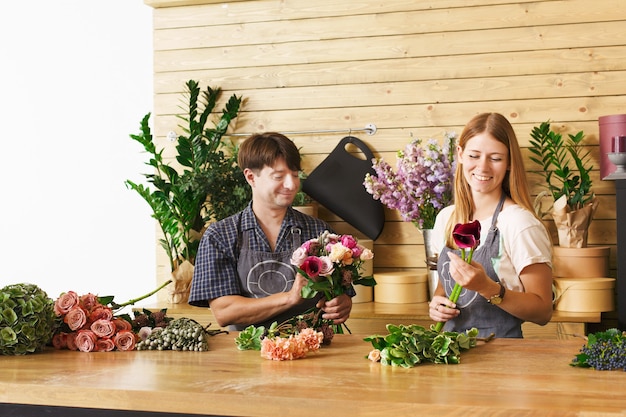 Pequeños negocios. Entrega de flores. Floristerías creando orden, haciendo ramo de rosas en florería.