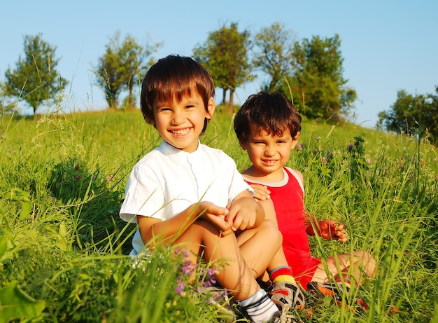 Pequeños niños lindos en hermoso campo verde