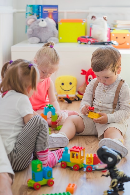 Pequeños niños sentados en el suelo jugando