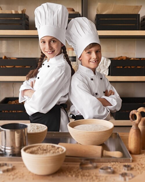 Foto pequenos padeiros confiantes trabalhando na cozinha