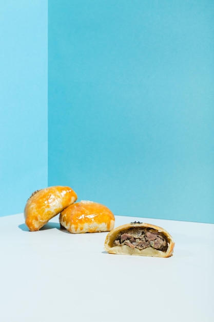 Pequeños pasteles fritos con carne samsa sobre fondo azul foto de alta calidad