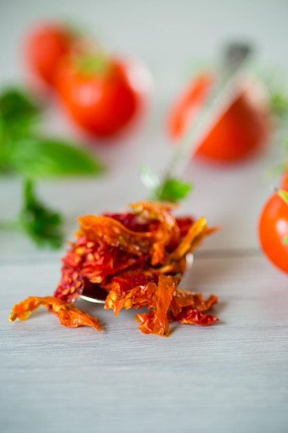 Foto pequenos pedaços de tomate seco ao lado de tomates frescos, especiarias caseiras naturais