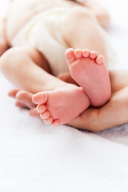 Pequenos pés. Close do pai segurando a mãozinha de seu bebê