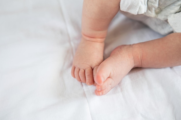 Pequeños pies de un bebé recién nacido en la cama, vista superior. El concepto de maternidad, lactancia.