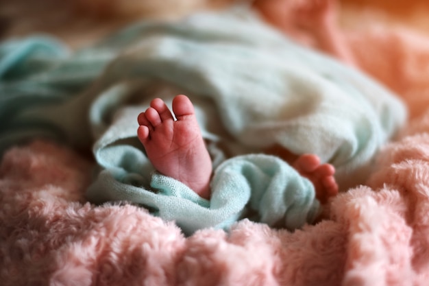 Pequeños pies de bebé recién nacidos lindos en la cama