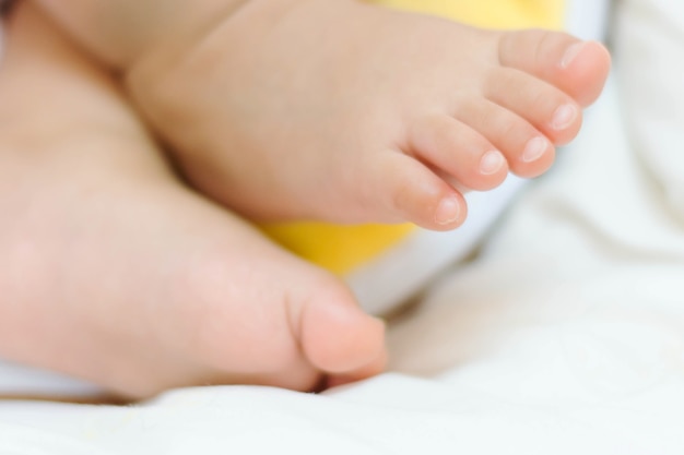 pequeños pies de lindo bebé asiático durmiendo en la cama en casa