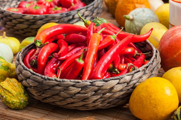 Pequeños pimientos rojos maduros en la cesta