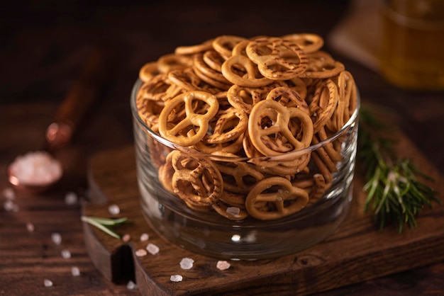 Pequeños pretzels salados con sal y especias en un recipiente de vidrio, primer plano