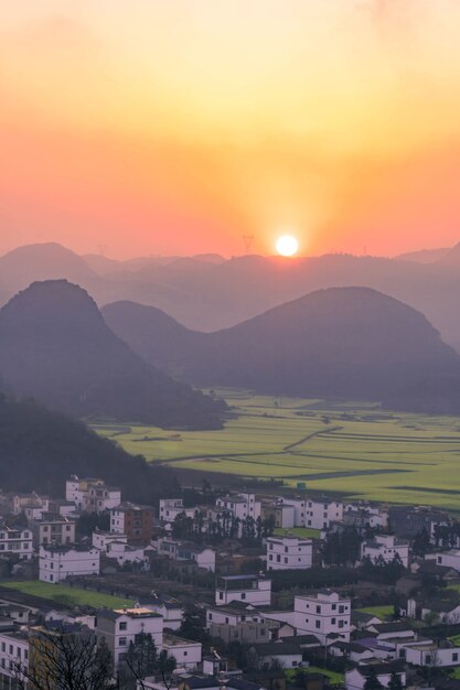 Pequeños pueblos con flores de colza en Jinjifeng (Golden Chicken Peak), China