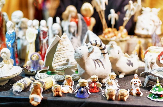 Pequeños recuerdos de cerámica en diferentes formas, tamaños y estilos exhibidos en el establo durante el mercado navideño en la antigua Riga, Letonia. enfoque selectivo