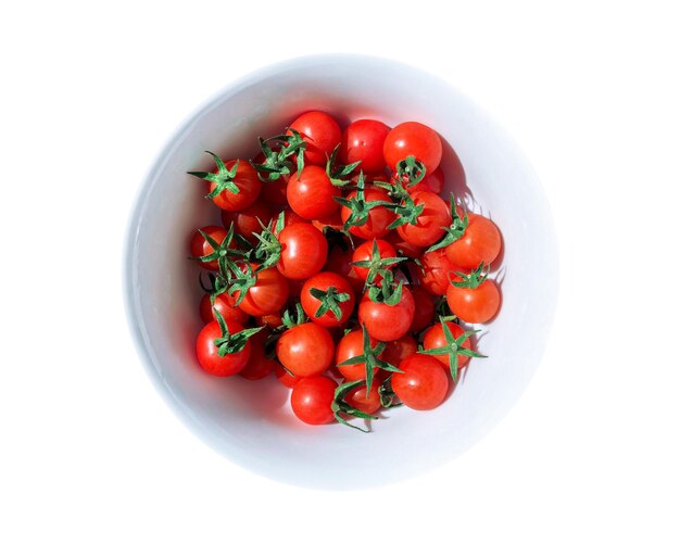 Pequenos tomates cereja frescos em uma tigela com guarda-sol. Planta de verão. Produto alimentar.