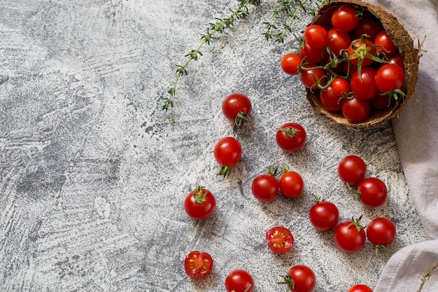 Pequeños tomates cherry (ciliegini, pachino, cóctel). Grupo de tomates cherry en un hormigón gris maduros y jugosos tomates cherry