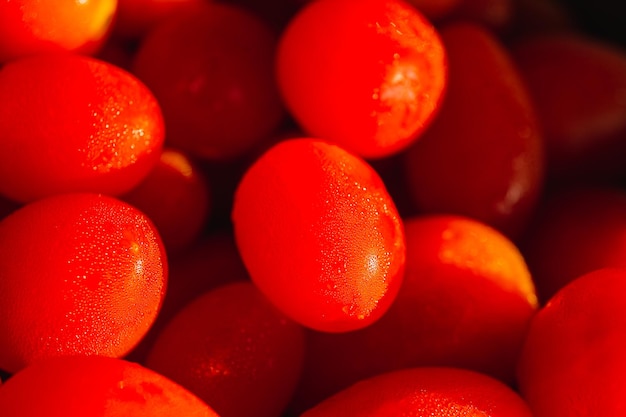 Pequeños tomates cherry rojos con fondo de gota de agua