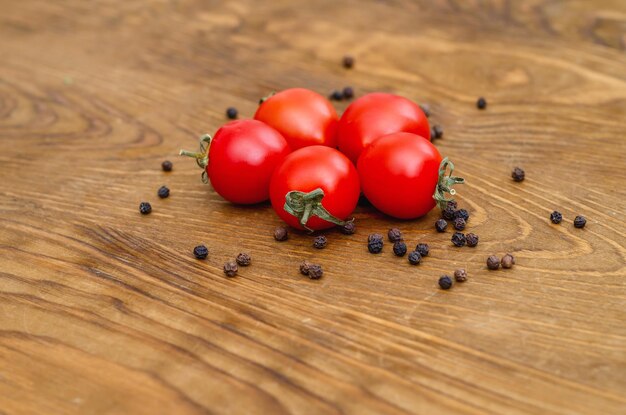 Pequeños tomates cherry rojos sobre fondo de tablero de madera doblados en círculo