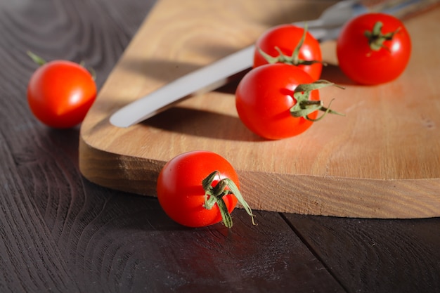 Pequeños tomates cherry en una tabla de cortar con un cuchillo