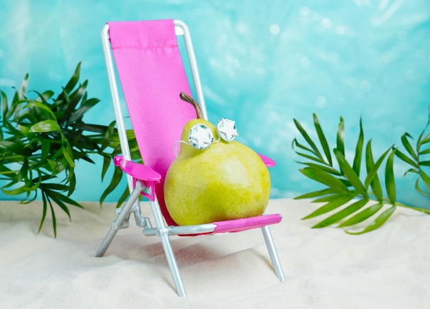 Foto pêra bonita com óculos de sol relaxa em uma cadeira de praia verão póster de humor minimalista tropical