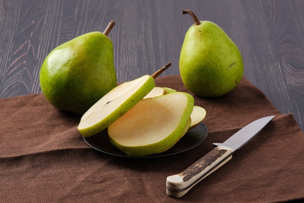 Pera y cuchillo en mesa de madera