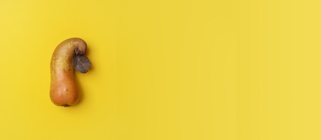 Una pera de forma extraña aislada en banner de fondo amarillo