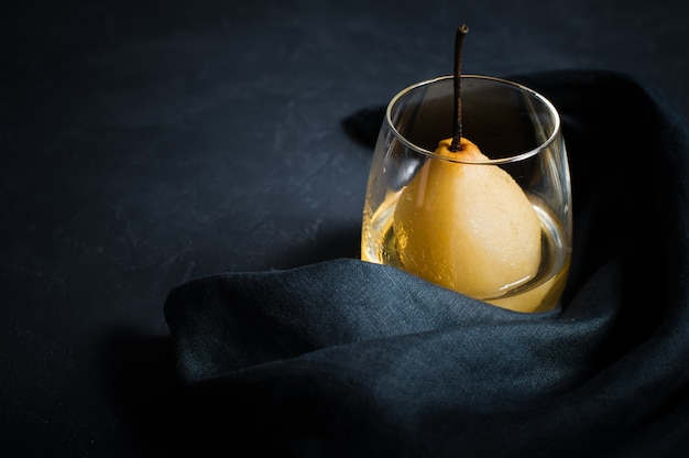 Pera pochada en un vaso, cocida en vino blanco.