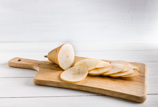 Pera en rodajas para hacer patatas fritas sobre fondo blanco con espacio de copia