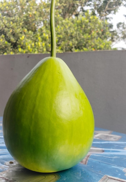 Foto una pera verde está en una mesa con un mantel azul