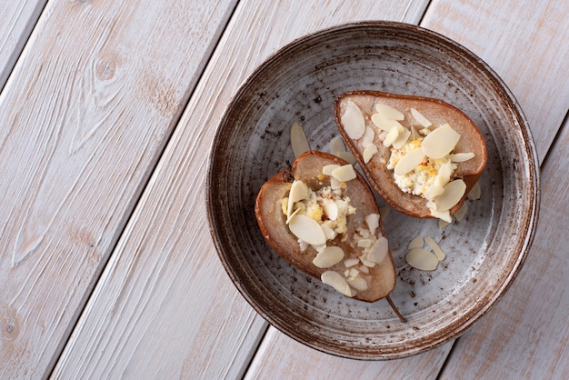 Peras al horno con requesón y miel decoradas con rodajas de almendras