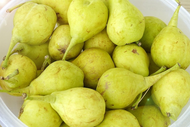 Peras amarillas maduras en una canasta de peras sin hormonas naturales