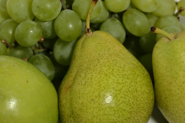 Peras e uvas verdes no fundo branco