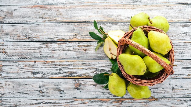 Foto peras frescas en una cesta de madera frutas espacio libre para texto vista superior