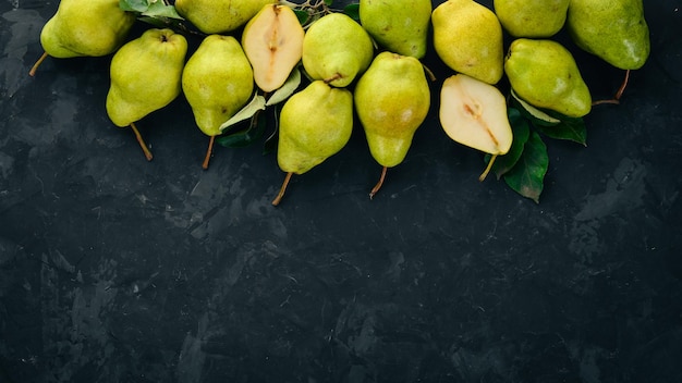 Peras frescas em uma mesa de pedra preta frutas espaço livre para texto vista superior