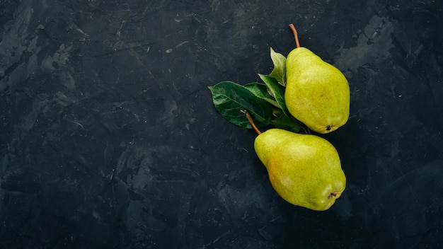 Peras frescas em uma mesa de pedra preta frutas espaço livre para texto vista superior