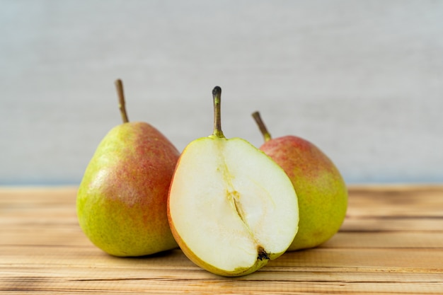 Peras frescas suculentas deliciosas na madeira