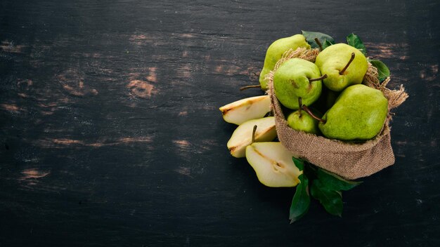 Peras frescas Um grande conjunto de peras Frutas Espaço livre para texto Em um fundo preto de madeira Vista superior