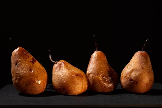 Peras maduras com fundo preto e iluminação quente