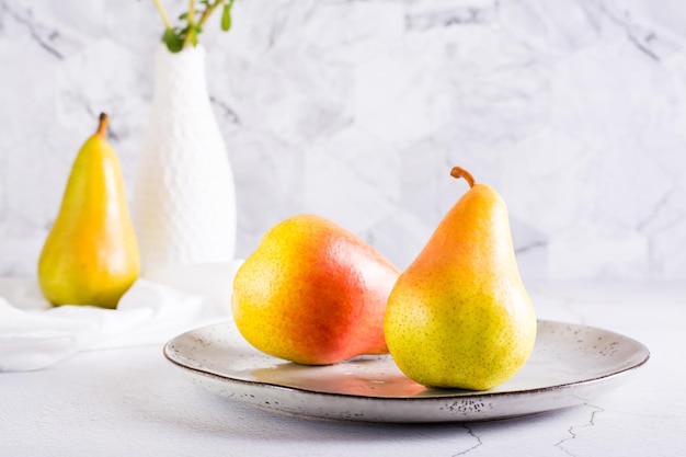 Peras maduras en un plato sobre la mesa Frutas de otoño