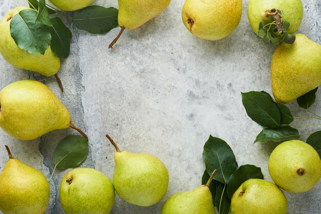 Peras Peras orgánicas dulces frescas con hojas en caja de madera o cesta sobre fondo de baldosas de piedra vieja Marco de frutas de cosecha de otoño Vista superior Fondo de alimentos Maqueta