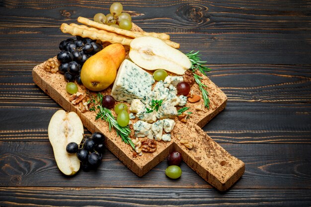 Peras y queso en tabla de cortar de madera