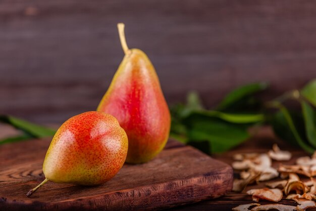 Peras rojas frescas con frutos secos caseros sobre fondo de madera, comida sana