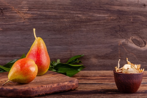 Peras rojas con frutas secas caseras en rodajas en taza de madera, concepto de comida saludable