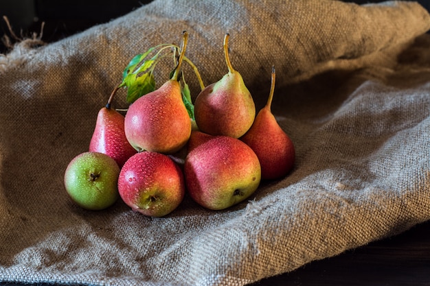 Peras rojas en la mesa de madera rústica, fondo natural, vegano, comida de dieta. Cosecha de otoño Ve