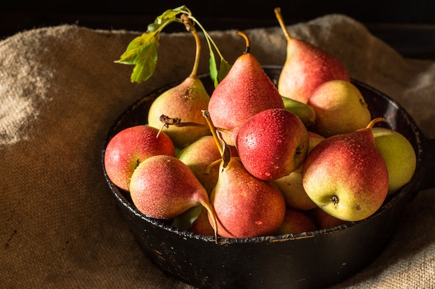 Peras rojas en la mesa de madera rústica, vegana, comida de dieta. Cosecha de otoño Frutas jugosas en bolsa. V