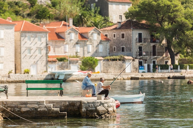PERAST MONTENEGRO 27 DE SETEMBRO DE 2016 Dois homens pescando em um passeio da popular cidade turística Perast Montenegro