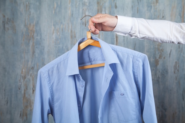 Percha de explotación de empresario con camisa azul.