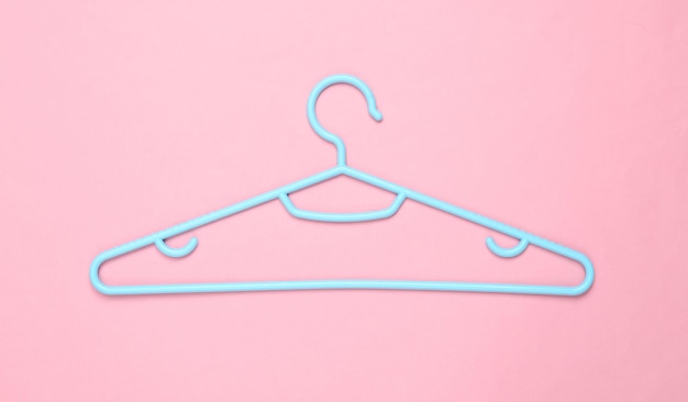 Percha de plástico azul sobre fondo rosa Diseño de moda Plano Vista superior