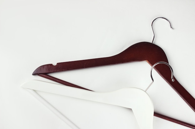 Perchas elegantes de madera de color marron oscuro y blanco sobre blanco. Traje de primavera otono Foto Premium