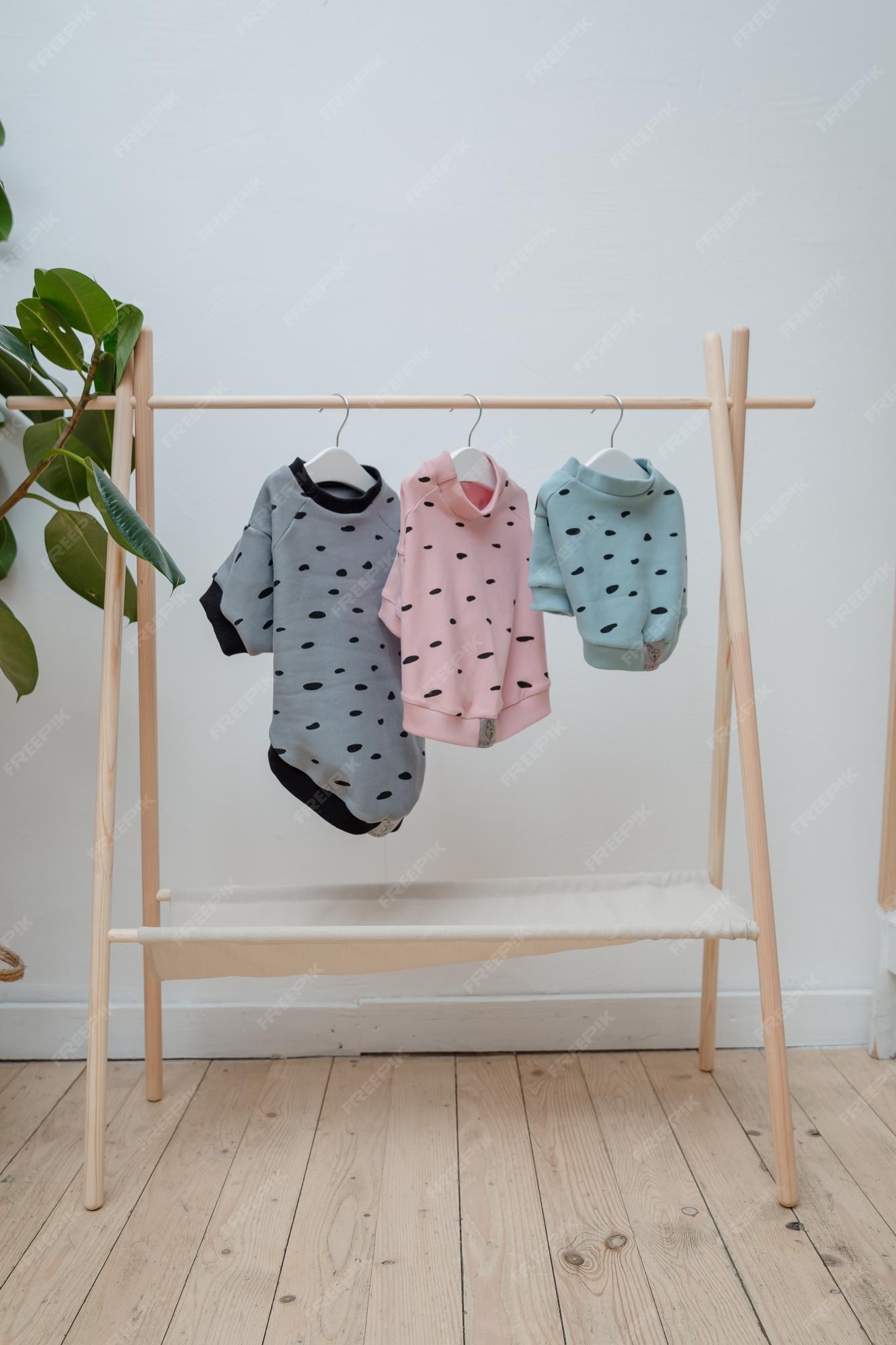 Un perchero para de bebé con camisa rosa gris. | Foto