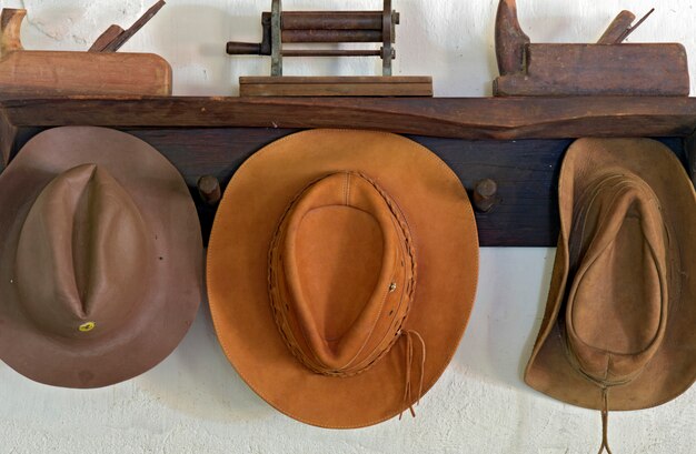 Perchero rústico con sombreros de cuero