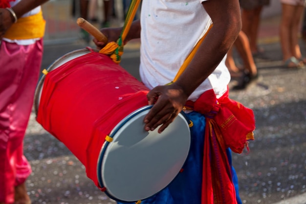 Percusionista tocando con un dholak durante el carnaval de Grand Boucan